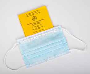 international vaccination certificate under a face mask