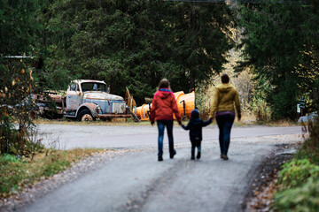 Obraz premium people walking on the road and a old car in front of them is in focus and the people are not