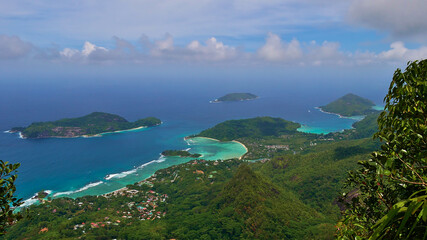 Panorama view from the top of mountain Morne Blanc, Mahe, Seychelles over the northwestern coastline of the island with tropical beach Anse l'Islette and Port Launay with turquoise colored water.