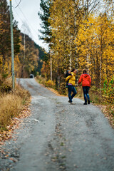 Fototapeta premium Mother, brother and sister are walking in the beautiful autumn forest. Viivis and strong colors. Shot in Gol, Hallingdal, Norway