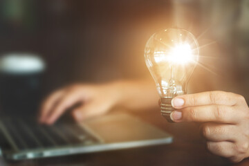 Ideas and inspiration concept, woman holding light bulb thinking a new project.