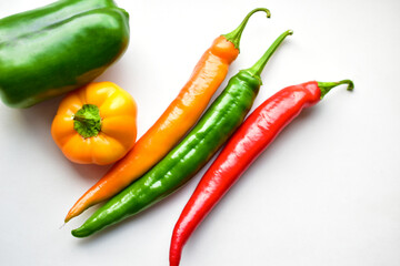 Regular and capsicum yellow and green pepper on a white background