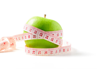 Measuring tape wrapped around a green apple isolated on white