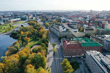 Aerial view of beautiful colorful old buildings in Helsinki, Finland. Fall color trees, park, sea shore and sunshine.