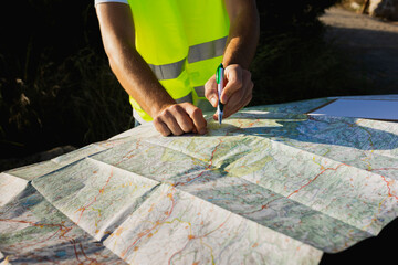 Young man looking for a location on a paper map