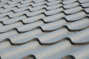 Gray metal roof tiles. House roofing system close-up
