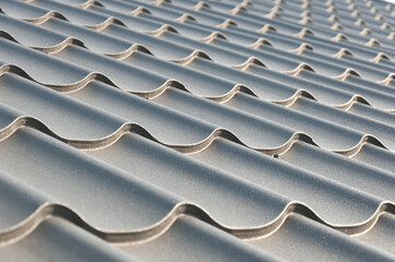 Gray metal roof tiles. House roofing system close-up