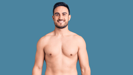 Fototapeta premium Young handsome man wearing swimwear looking positive and happy standing and smiling with a confident smile showing teeth