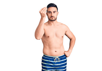 Young handsome man wearing swimwear doing italian gesture with hand and fingers confident expression