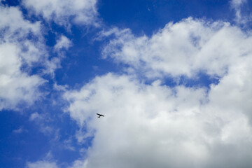 Blue sky with some clouds and a plane