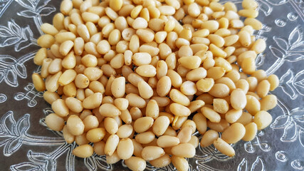 pine nuts on a plate against a dark background