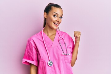 Young hispanic woman wearing doctor uniform and stethoscope smiling with happy face looking and...