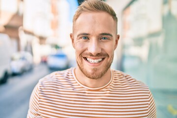 Young irish man smiling happy walking at street of city.