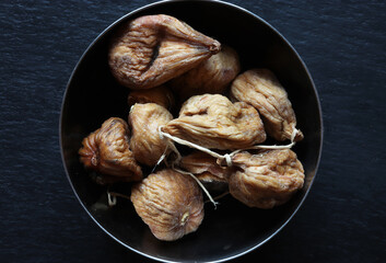 Photography of a baglama figs in a stainless steel bowl on slate background for food illustrations