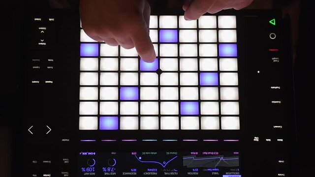 Overhead perspective of music producer using a sequencer in the studio to compose a song