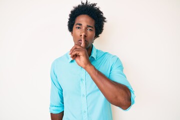 Fototapeta na wymiar Handsome african american man with afro hair wearing casual clothes asking to be quiet with finger on lips. silence and secret concept.