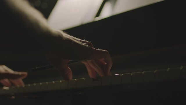 A person is playing a piano in the dark