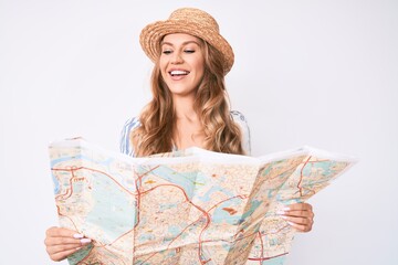 Young caucasian woman with blond hair wearing summer hat holding map smiling with a happy and cool smile on face. showing teeth.