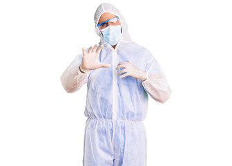 Young hispanic man wearing doctor protection coronavirus uniform and medical mask disgusted expression, displeased and fearful doing disgust face because aversion reaction. with hands raised