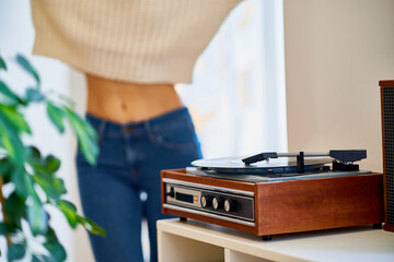 Woman dancing to music on vinyl record player