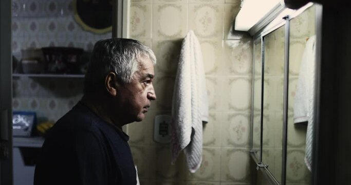 Middle-aged man in crisis in front of mirror