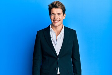 Handsome caucasian man wearing business suit and tie looking positive and happy standing and smiling with a confident smile showing teeth
