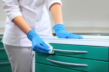 Disinfection in the dental office. A doctor's assistant wipes the furniture in the dental office....
