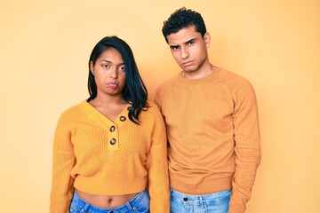 Beautiful latin young couple wearing casual clothes together depressed and worry for distress, crying angry and afraid. sad expression.