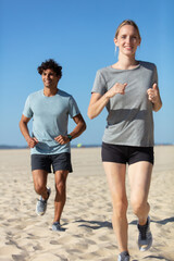 couple running on beach training for marathon run
