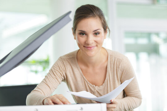 Happy Woman Next To A Photocopy Machine