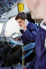 technician holding telephone in aircraft cockpit - obrazy, fototapety, plakaty