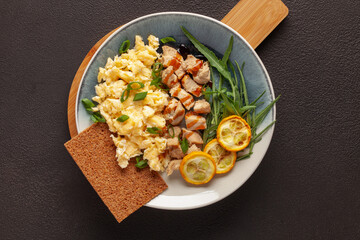 Diet breakfast - chicken fillet with scrambled eggs and zucchini grill and fresh vegetables. Top view