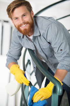 man clean banister of a staircase
