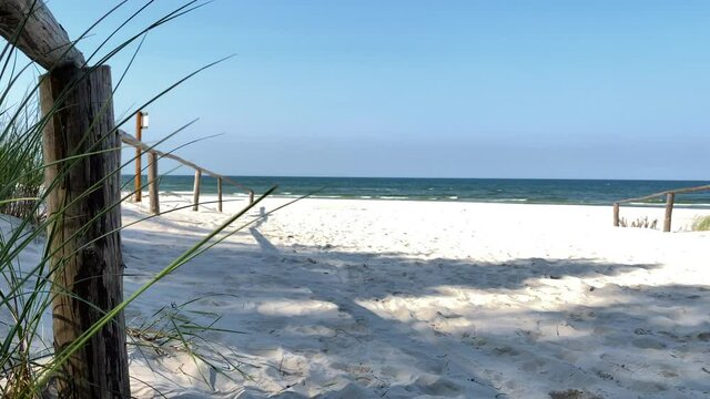 White Sand Beach Overlooking The Calm Blue Sea And Bright Sky In Summer From The Shore. - wide shot