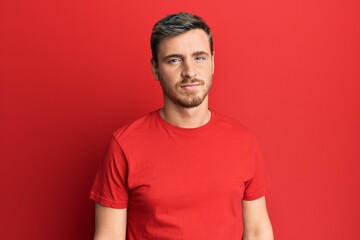 Handsome caucasian man wearing casual red tshirt looking sleepy and tired, exhausted for fatigue...