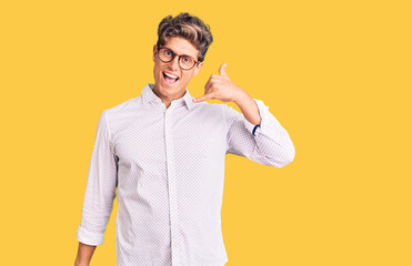 Young handsome man wearing business clothes and glasses smiling doing phone gesture with hand and fingers like talking on the telephone. communicating concepts.