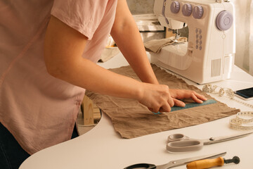 close up female hands with ruler ,chalk  and cotton textile, sewing concept