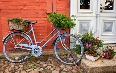 Fototapeta na wymiar bike with decorative flower pot in front of a house