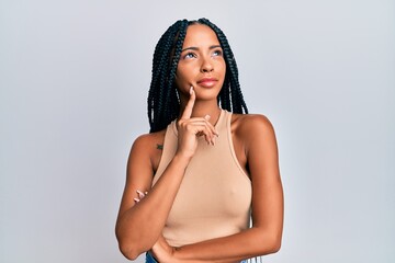 Beautiful hispanic woman wearing casual clothes thinking concentrated about doubt with finger on...