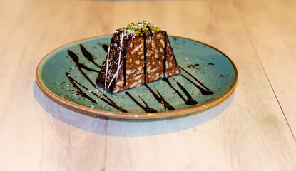 Chocolate mosaic cake on blue porcelain plate