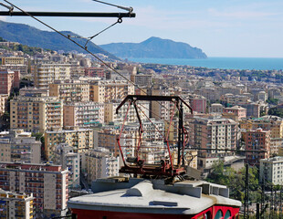 Linea ferroviaria elettrica di alimentazione di una funicolare a cremagliera. Sullo sfondo la città ligure di Genova con il promontorio di Portofino. 