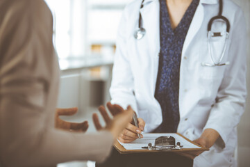 Doctor and patient discussing current health examination while sitting in clinic. Perfect medical...