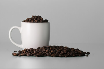 Blank white cup full of coffee beans. White mockup