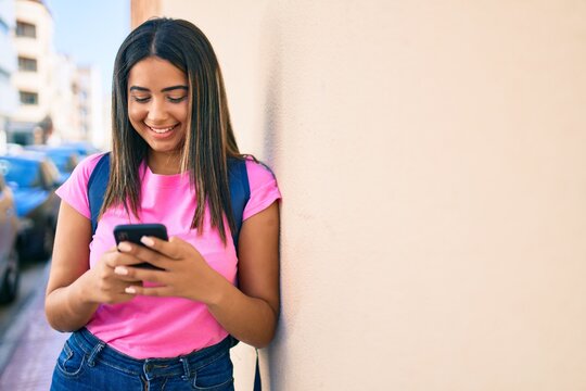 Young latin student girl smiling happy using smartphone at university campus.