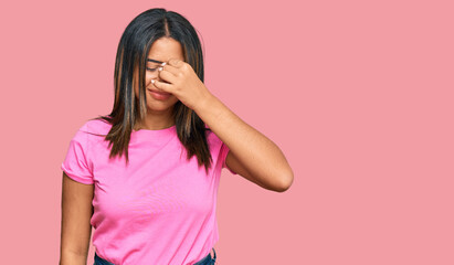 Young latin girl wearing casual clothes tired rubbing nose and eyes feeling fatigue and headache. stress and frustration concept.