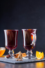 Mulled wine on a slate board. Two glasses of hot mulled wine and ingredients. Christmas hot drink with wine and honey