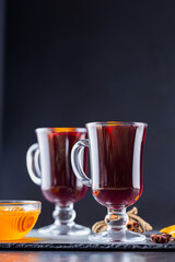 Mulled wine on a slate board. Two glasses of hot mulled wine and ingredients. Christmas hot drink with wine and honey