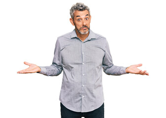 Middle age grey-haired man wearing casual clothes clueless and confused expression with arms and...