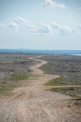 POVLJANA, PAG ISLAND, CROATIA, 10.10.2020. - Dirty road on the island of Pag leading to pastures for sheep. Karst landscape. Desert landscape.