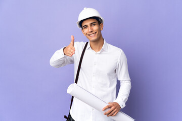 Young architect man isolated on background shaking hands for closing a good deal